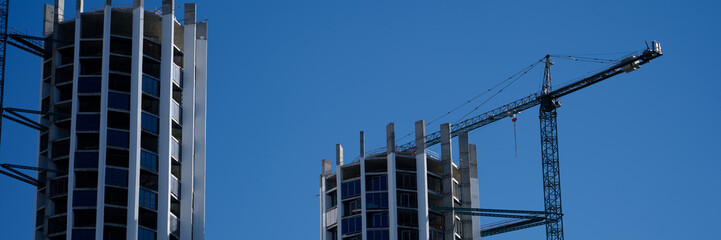 Beautiful residential buildings under construction outdoors and construction crane