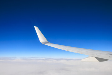 飛行機の翼と青空と眼下の雲