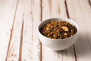 Chocolate breakfast cereal. Morning chocolate granola with dried banana on a black table.