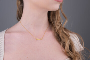 Gold initial necklace on neck of attractive white dress girl. Personalized necklace image. Jewelry photo for e commerce, online sale, social media