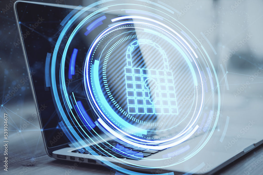 Poster close up of laptop computer on desktop with creative glowing blue padlock hologram on blurry backgro