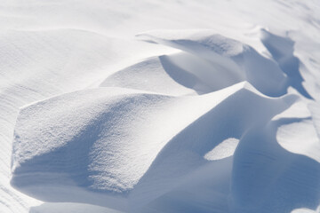 Snow drifts in the sunlight.