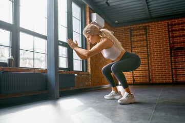 Woman training legs muscles with jump and squat