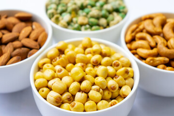 Grains in white bowl such as  lotus seeds,almond,cashew and pea are producing plant,commercial grain crops are cereals and legumes.Grains well suited to industrial agriculture for milled,flour,oil.