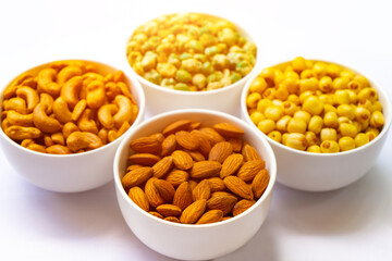 Grains in white bowl such as  lotus seeds, almond, cashew and pea are producing plant, commercial grain crops are cereals and legumes.Grains well suited to industrial agriculture for milled,flour,oil.