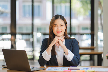 Obraz premium business woman or accountant who are using a calculator to calculate business data Accounting documents and laptop computer at the office business idea