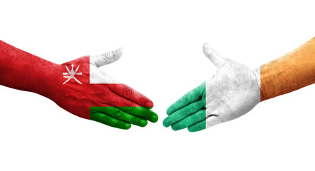 Handshake between Ireland and Oman flags painted on hands, isolated transparent image.