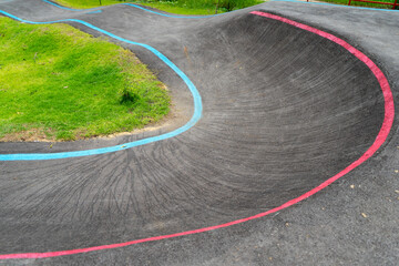 Off-Road Cycling Course.Asphalted bicycle pump track, racing speed track with traffic lines for ...