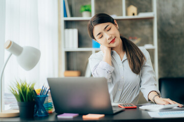 Portrait of smiling happy beautiful Asian woman relaxing using technology of laptop computer while sitting on table.Young creative girl working and typing on keyboard at cafe.work at home concept