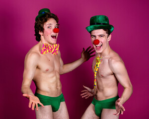 Beautiful gay couple in clown hats posing in the studio.