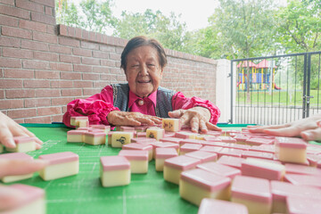 An old active elderly playing mahjong
