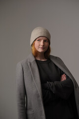 young girl model in beige hipster hat and coat isolated on light background. Product photo mockup for fashion brands and marketplaces, woolen cap, turkish textiles.