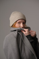 young girl model in beige hipster hat and coat isolated on light background. Product photo mockup for fashion brands and marketplaces, woolen cap, turkish textiles.