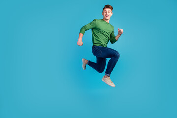 Fototapeta na wymiar Full portrait of crazy excited handsome man jumping hurrying fast isolated on shine blue background