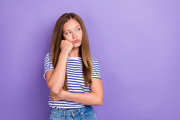 Photo of displeased upset girl straight hairdo wear striped t-shirt look empty space hand on cheekbone isolated on purple color background