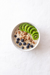 Oatmeal with kiwi, blueberries, almonds and honey. Healthy food. Vegetarian food. Breakfast.
