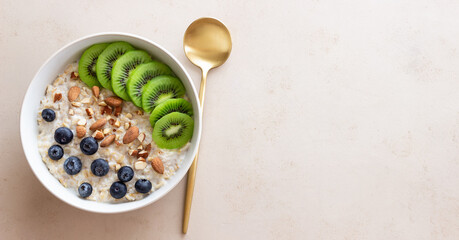 Oatmeal with kiwi, blueberries, almonds and honey. Healthy food. Vegetarian food. Breakfast.