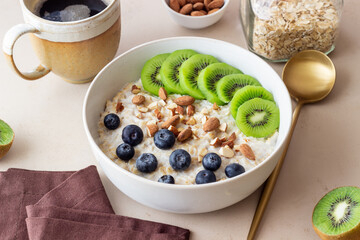 Oatmeal with kiwi, blueberries, almonds and honey. Healthy food. Vegetarian food. Breakfast.