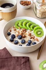 Oatmeal with kiwi, blueberries, almonds and honey. Healthy food. Vegetarian food. Breakfast.