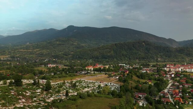 Aerial drone view, over Vulcan, is a small town in the mountains of the Hunedoara region in Romania. The town is situated in the midst of a valley with mountains all around. There are houses dotting t