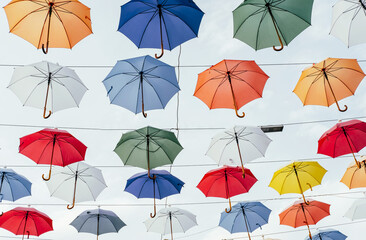 Fototapeta na wymiar Many colorful umbrellas background. Opened umbrellas in the sky. Urban decoration. Bottom view.