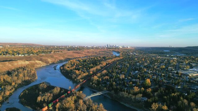 City of Calgary during golden hour from a aerial shot with a train passing over the Bow River
