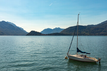 Sail boat moored on Lake Como with Bellagio on opposite lakeside