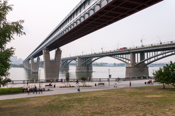 Fototapeta premium Novosibirsk, Russia, August 2022: Embankment in Novosibirsk and bridges across the Ob River in summer