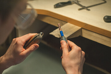 Close-up crafting man polishing a ring. Man crafts jewelry. Jewelry crafting. Art jewelry.