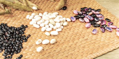 Heaps of peeled beans and empty pods on a straw mat