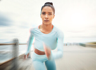 Woman, running and exercise motion blur by ocean, sea or promenade for health, fitness and...
