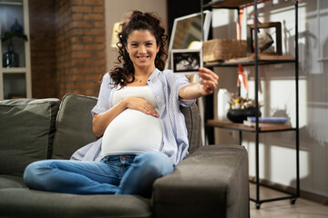 Pregnant woman with ultrasound photo. Beautiful pregnant woman enjoy at home.