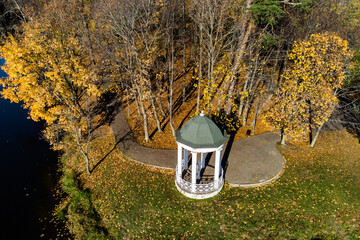 Rotunda in the autumn park on the shore of the reservoir. Belkino estate park, Obninsk, Russia