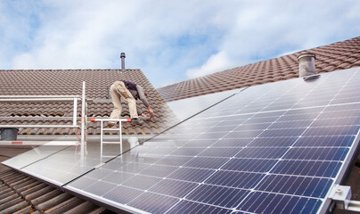 Roofer, worker on the rooftop. Roofing work. Solar Cell Installation. Preparation of Solar panel...