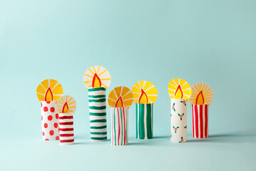 The child DIY for Jewish holiday of Hanukkah. Traditional candlestick 7 candles from toilet tube, recycle concept. Children's Art Project, needlework, crafts for children.