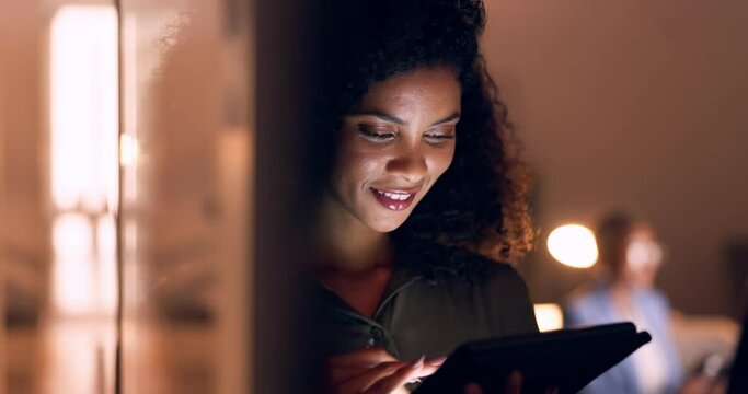 Office, night and happy black woman on a tablet at her job in the dark smiling about funny text. Business, technology and social media mobile app scroll of a person working late on a work break