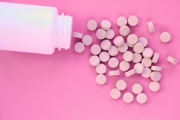 Tablets, capsule, pills and white plastic pack on pink background. Vitamin prescription supplement,...