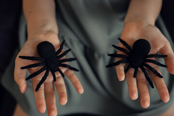 Big black spider on child's hands, halloween concept. High quality photo