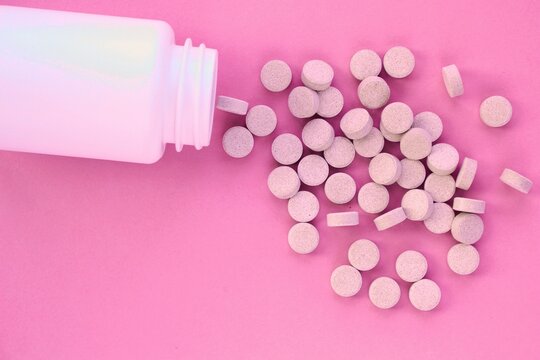 Tablets, capsule, pills and white plastic pack on pink background. Vitamin prescription supplement, drugs, Pharmaceutical medicine health therapy idea. Suicide abuse overdose concept. Doping steroid