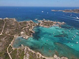 Fototapeta na wymiar Aerial view of La Maddalena Island, Isola Giardinelli with the drone view of Caprera Island in Sardegna, Italy. Birds eye view of crystalline and turquoise water in north Sardinia, luxury yacht, boat.