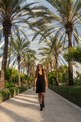 Fototapeta na wymiar Beautiful woman in black dress in interior garden in Valencia, Spain