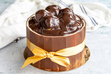 Cake with chocolate and profiteroles on a gray background. Birthday or celebration cake. close up