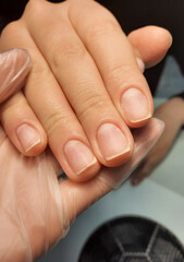 Treated nails on the background of a manicure vacuum cleaner. Neat manicure on nails without gel polish coating.