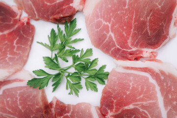 Raw Pork Slice in White Round Plate decorated with parsley. Fresh raw pork.