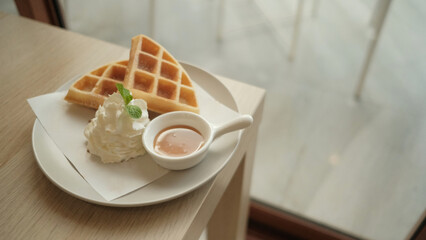 Waffles served with whipped cream and caramel.