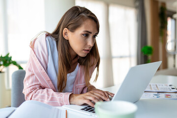 Young woman working laptop. Business woman busy working on laptop computer at office. Businesswoman sitting at bright modern work station and typing on laptop