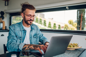 Young business man working at home with laptop and papers on desk