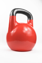 Classic red heavy cast iron kettlebell shot in a white studio.