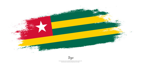Obraz premium Happy Independence Day of Togo. National flag on artistic stain brush stroke background.