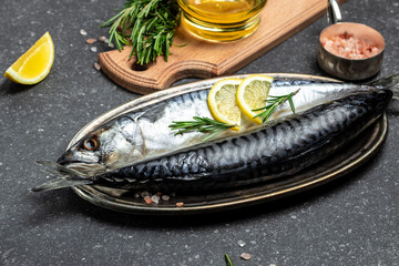 scomber, marinated mackerel or herring fish with salt, lemon and spices on a dark background....